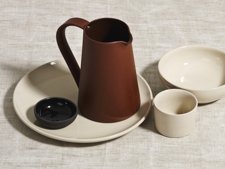 A stonewear set with a plate, bowl, cup, and pitcher.